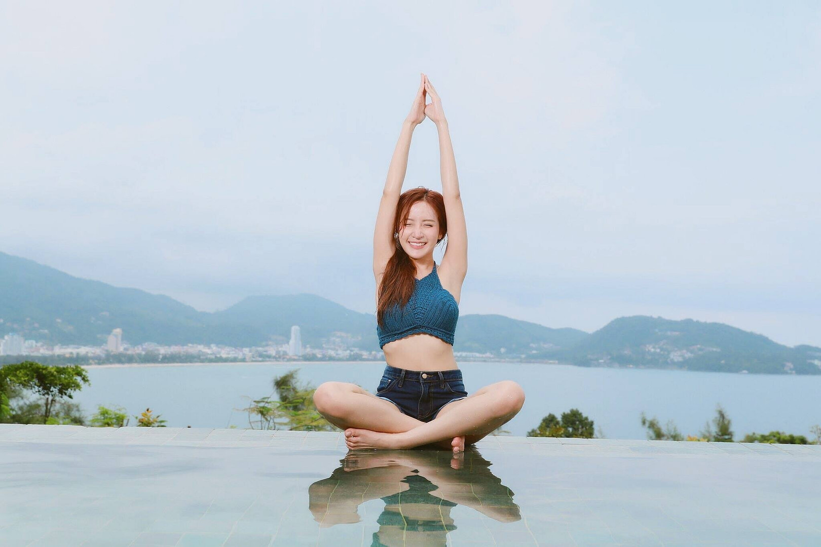 Woman sitting cross legged on floor outside in yoga / meditation pose